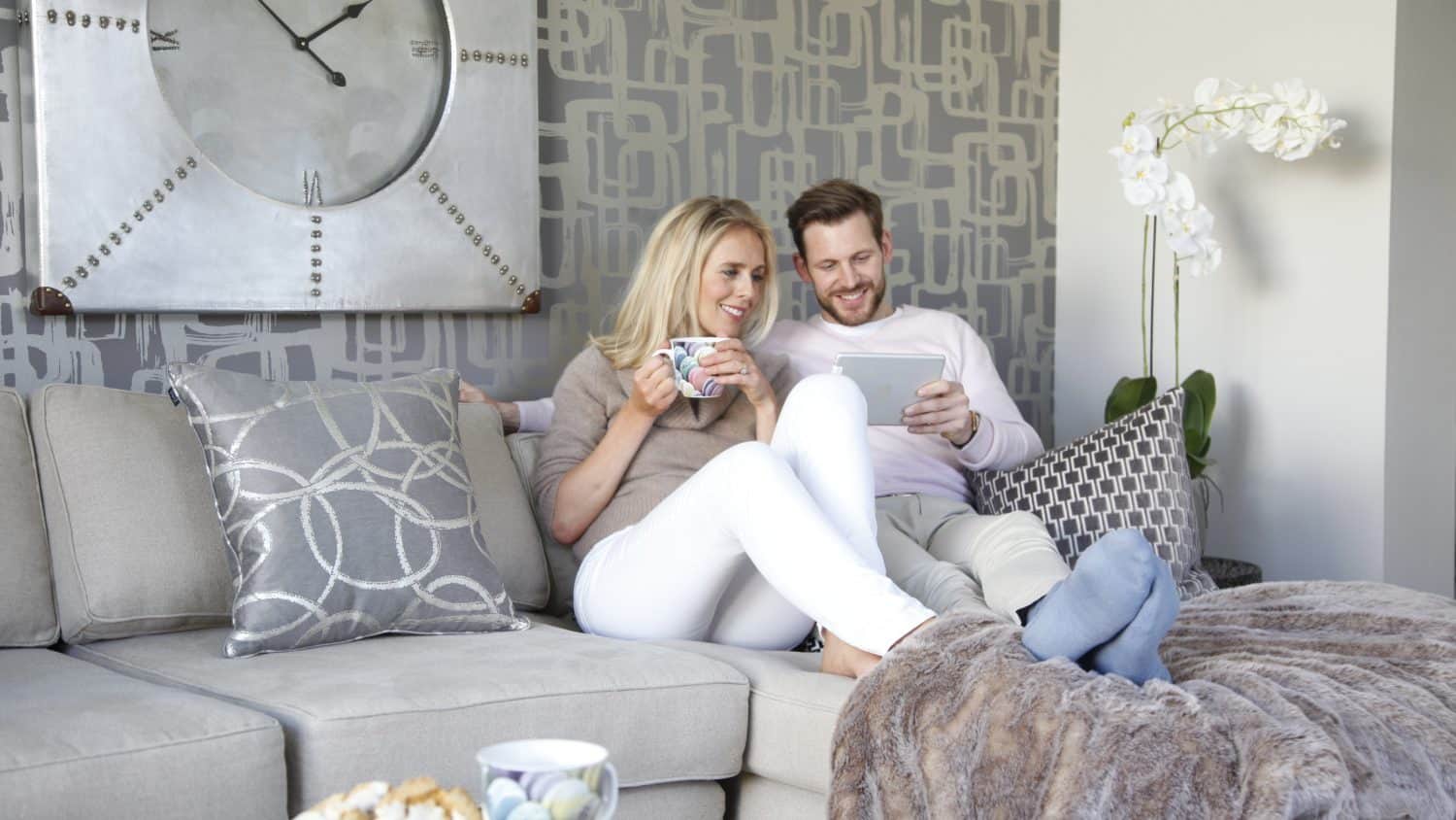 young couple on sofa in lounge on tablet computer