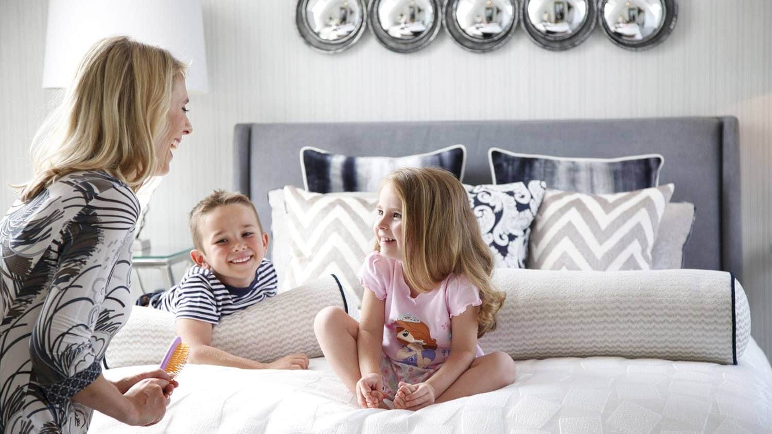 family playing on bed in newbuild home