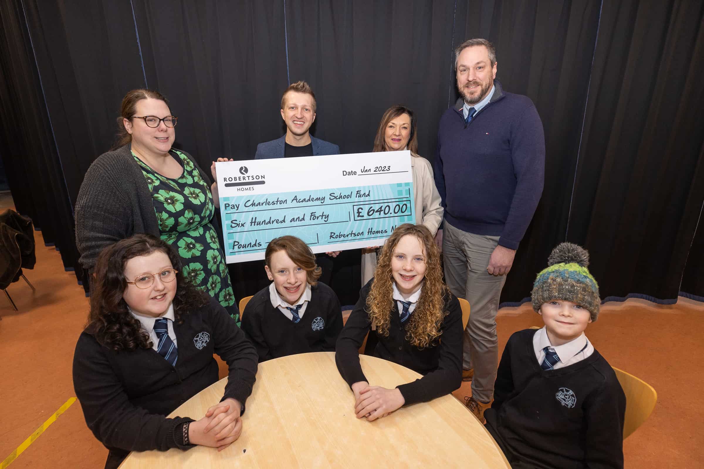 Roberston Homes presents Charleston Academy School Fund a cheque for £640 towards their Breakfast Club.

Pictured with Charleston pupils are;  teacher Eileen MacLeod, acting head teacher Andrew Brown with Jacqui McPherson, Sales Manager and Neil Mackinlay, Commercial Manager both of Robertson Homes.